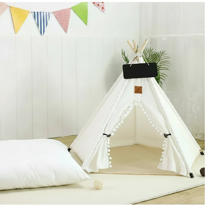 White pet teepee with a dog lying on a cushion, colorful flags in the background